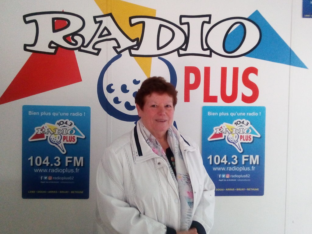Photo d'Odette Duriez, conseillère départementale du pas-de-calais, posant devant le logo de Radio Plus