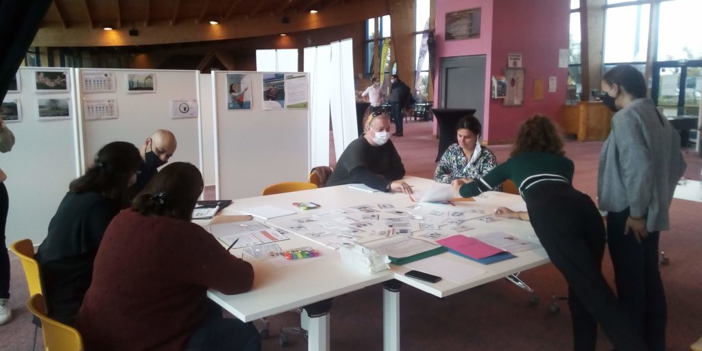 7 personnes autour d'une table participent à un atelier sur l'emprunte écologique du numérique.